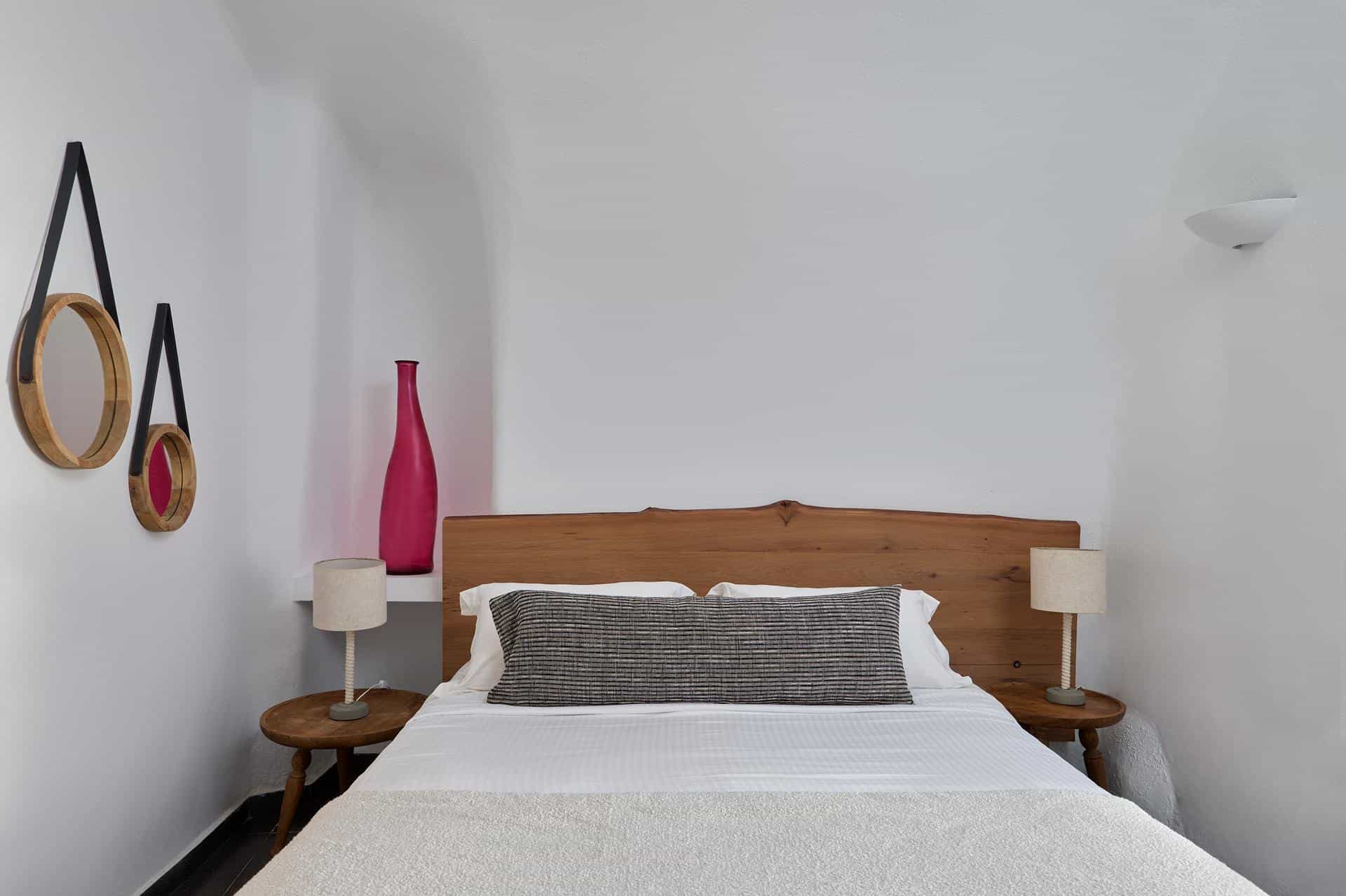 Whitewashed cave suite bedroom with arched ceiling at Aroma Suites