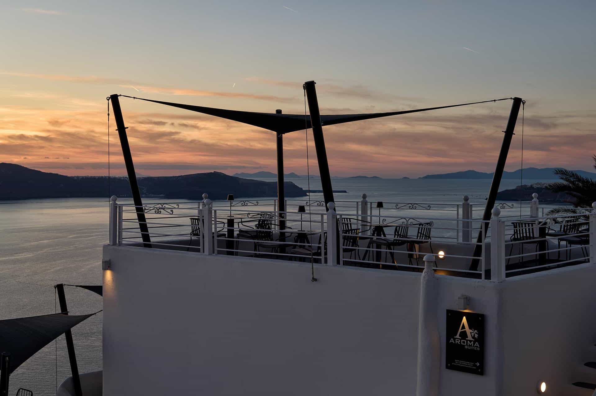 Rooftop terrace with sail shade at sunset at Aroma Suites