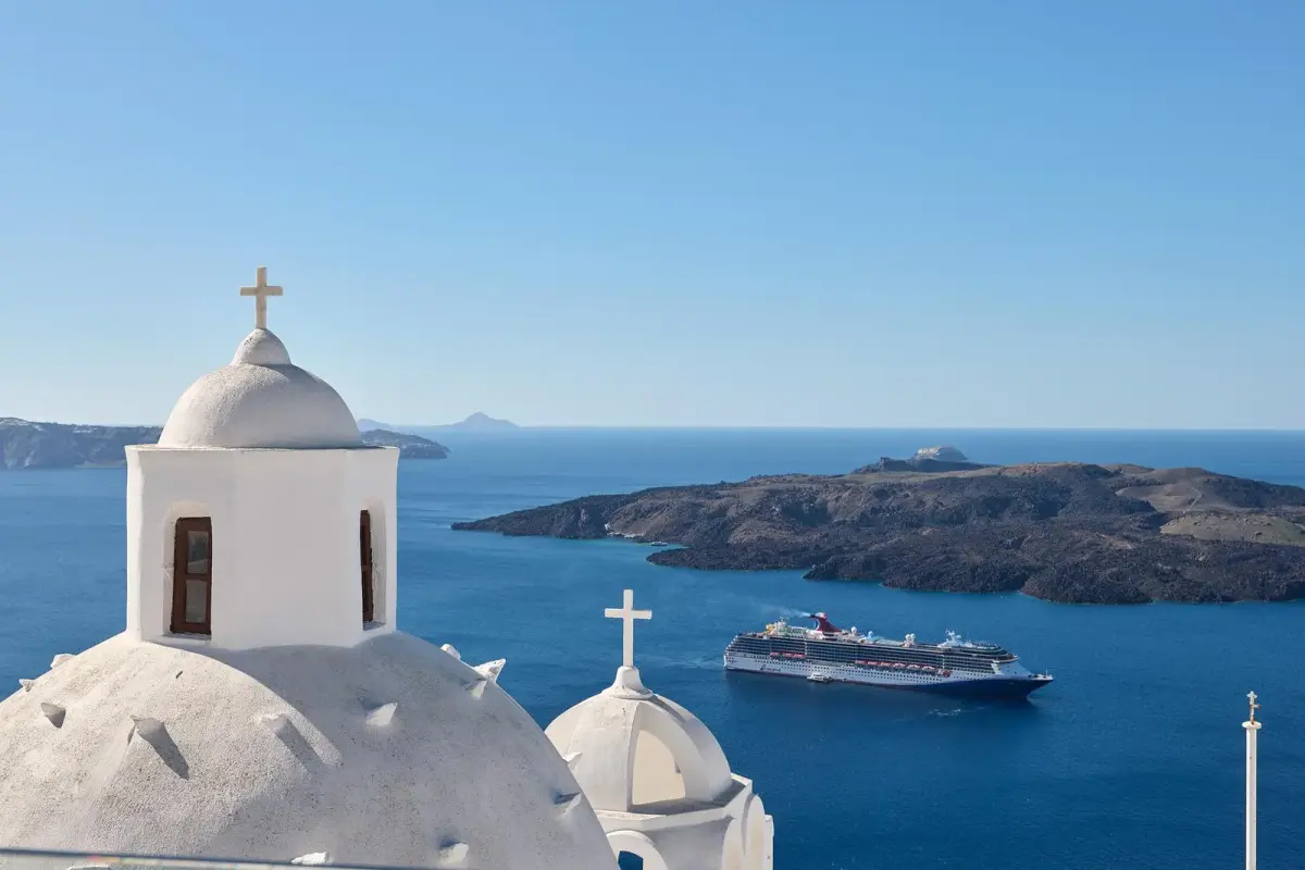 Church domes above the caldera, with Nea Kameni and a cruise ship, seen from Aroma Suites in Fira