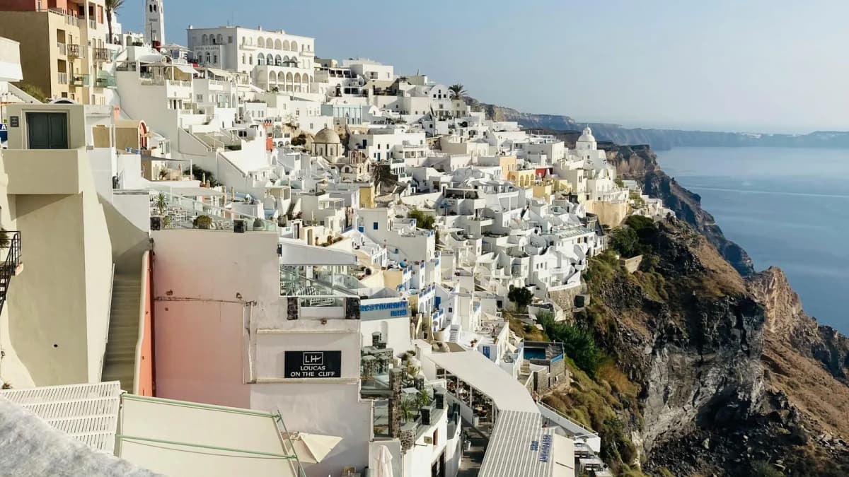 Whitewashed hotels and buildings in Fira perched on the Santorini caldera cliffs overlooking the Aegean Sea