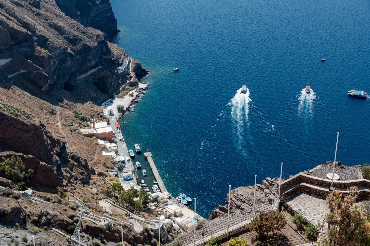 Fira's old port from the cliff top, with the cable car line, the stepped path and boats in the bay