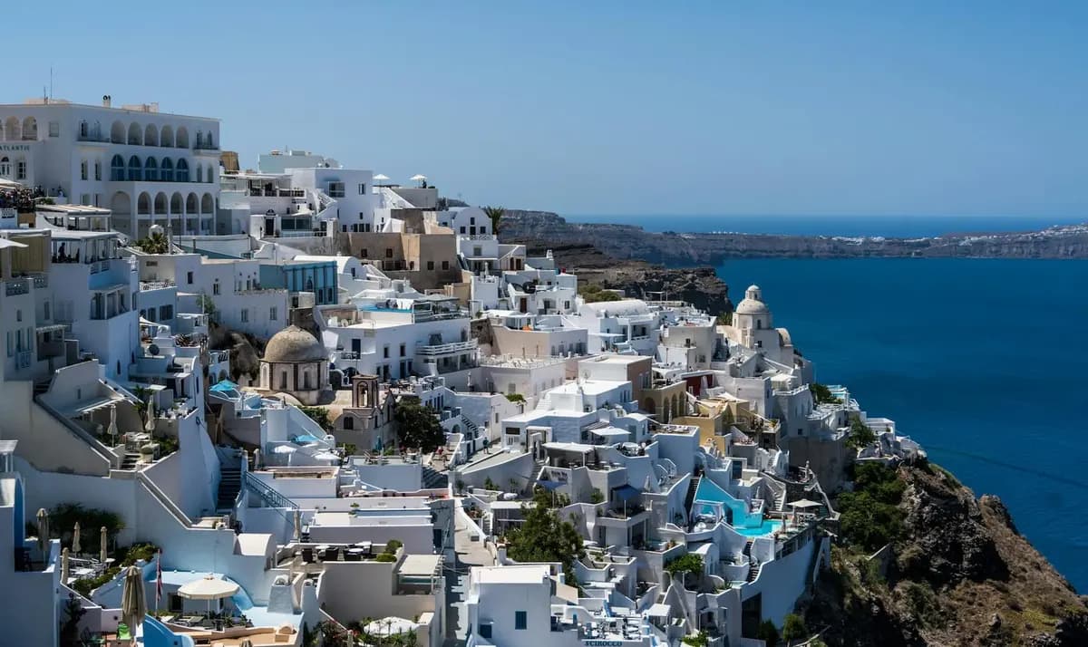Fira town at sunset with caldera views, whitewashed buildings, and church domes