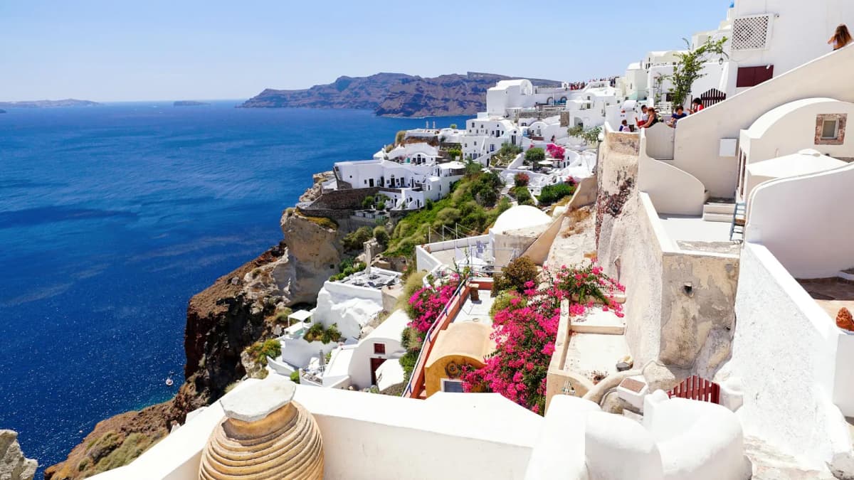Hikers walking the Fira to Oia caldera trail with panoramic views of the Santorini caldera
