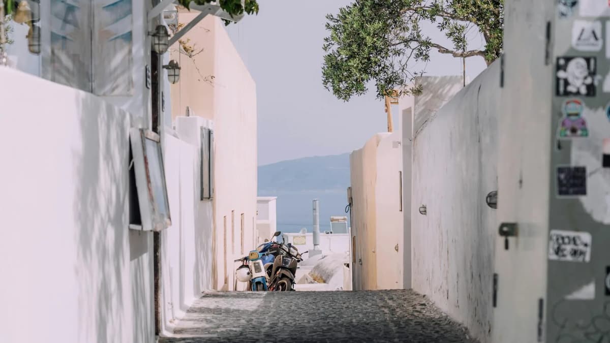 Cobblestone street winding through traditional whitewashed Greek architecture in Santorini village