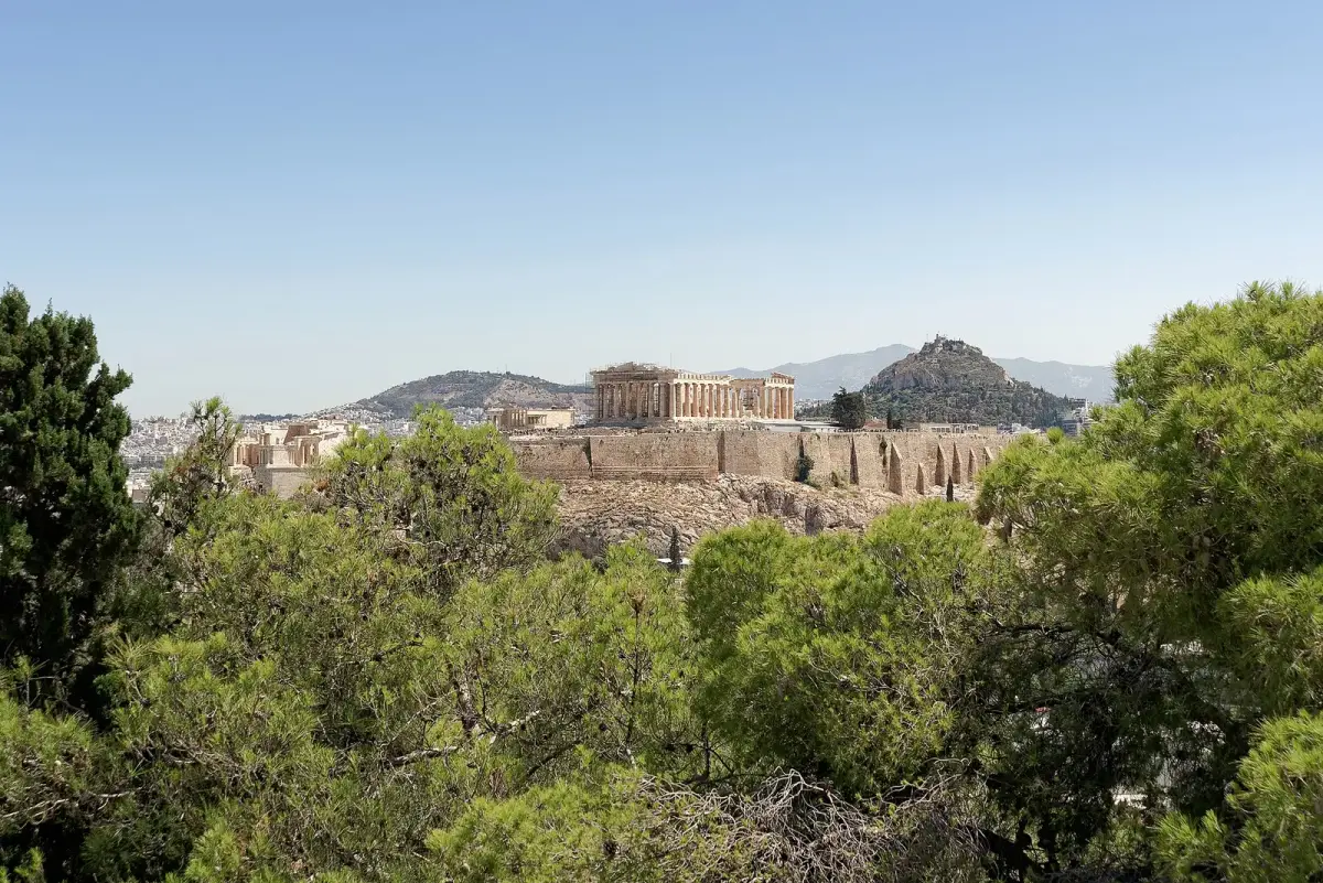 The Acropolis and the Parthenon above Athens, seen through pine trees from Philopappos Hill, with Lycabettus Hill behind