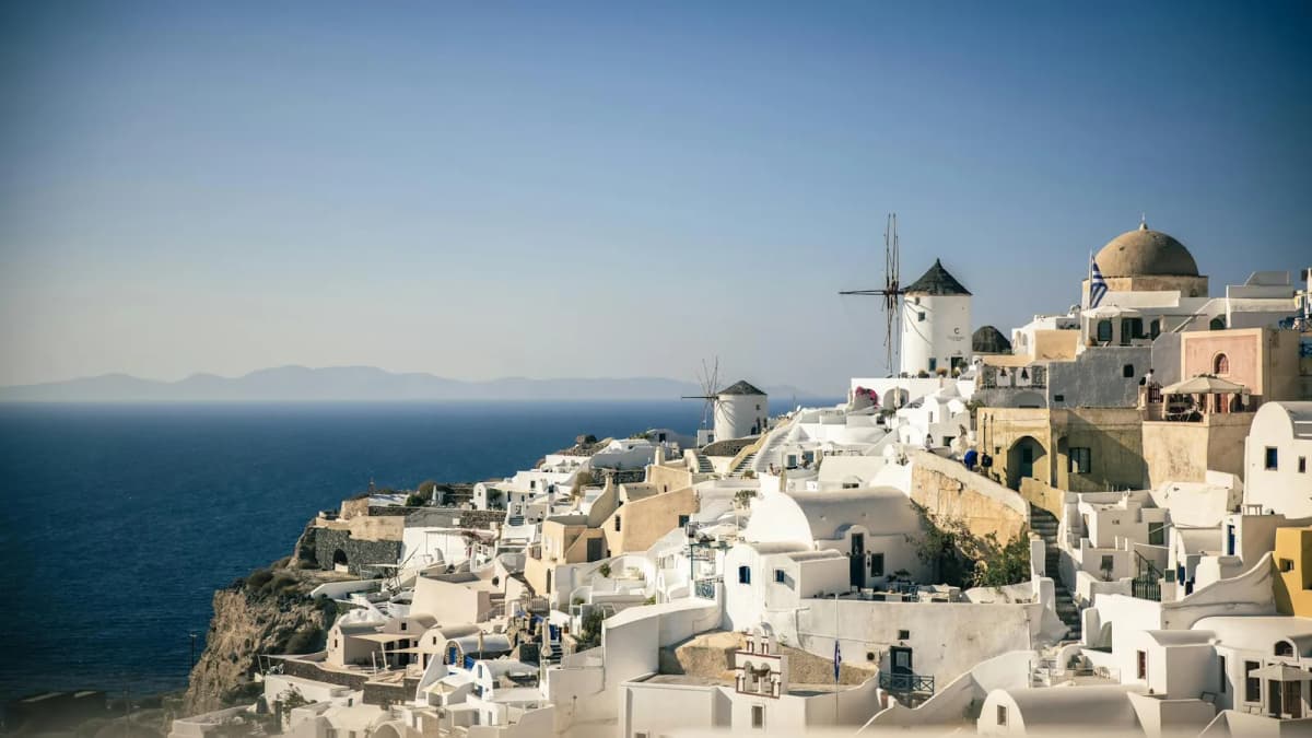 Oia village in Santorini with iconic white buildings and blue domes overlooking the caldera