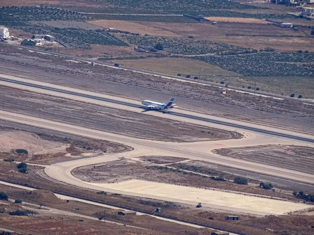 A passenger jet on the runway at Santorini airport, seen from Mount Profitis Ilias