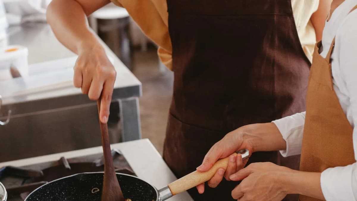 Two women cooking traditional Greek dishes together during a Santorini cooking class