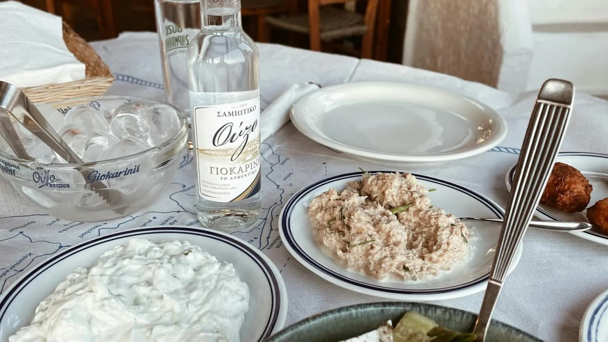 Traditional Greek cuisine spread with ouzo and mezze dishes at a Santorini taverna