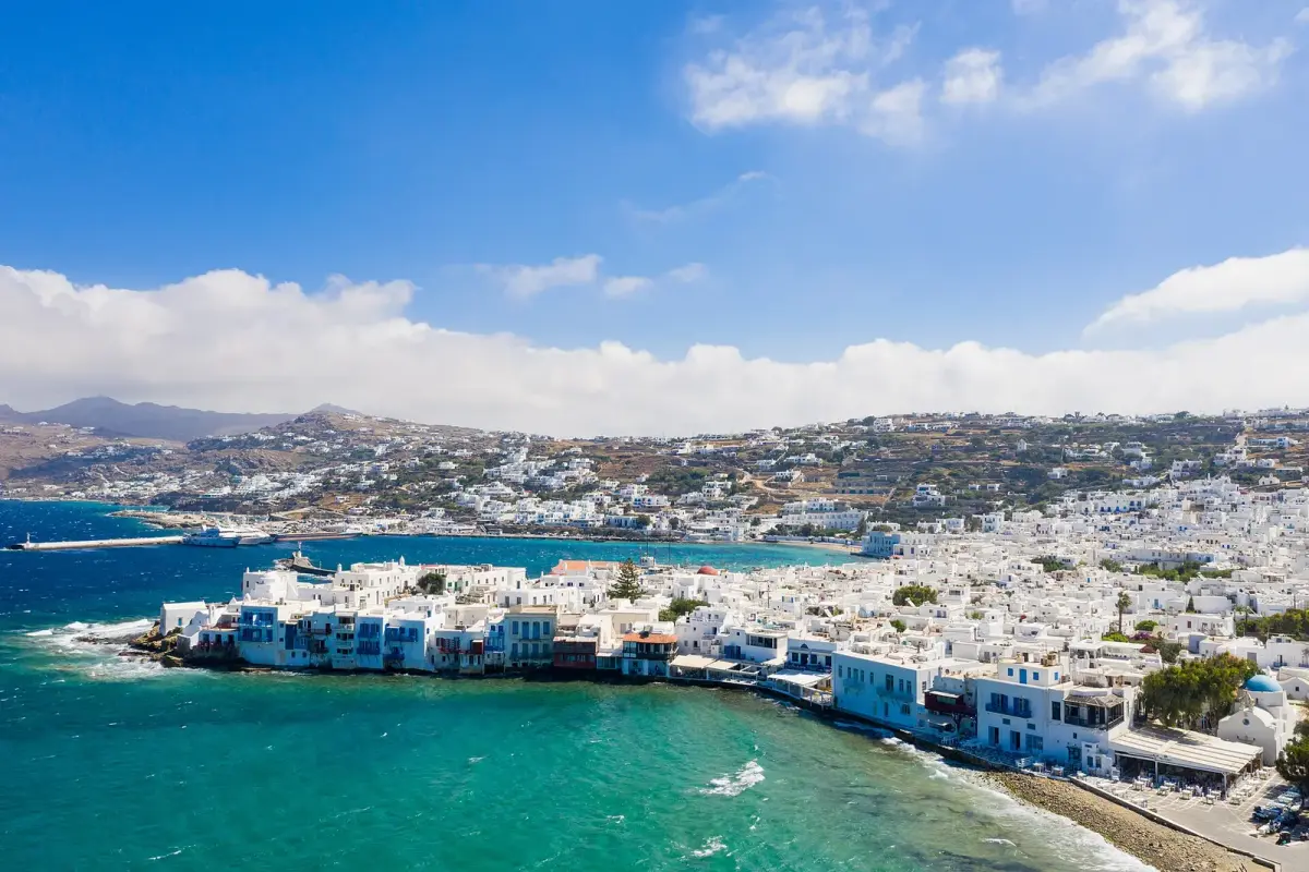 Aerial view of Little Venice in Mykonos town, with the old harbour and a moored ship across the bay