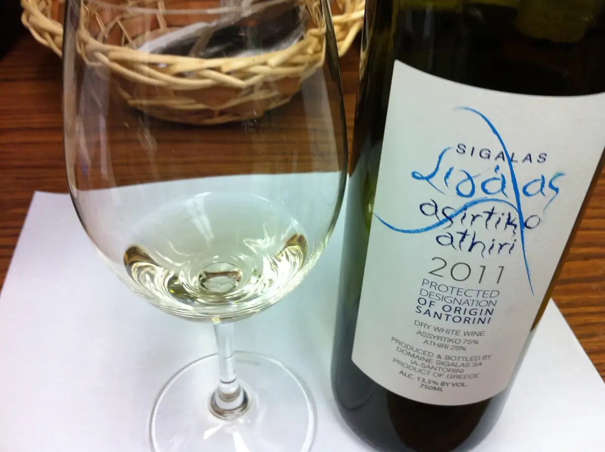 A glass of white wine beside a bottle of Sigalas Assyrtiko-Athiri from Santorini