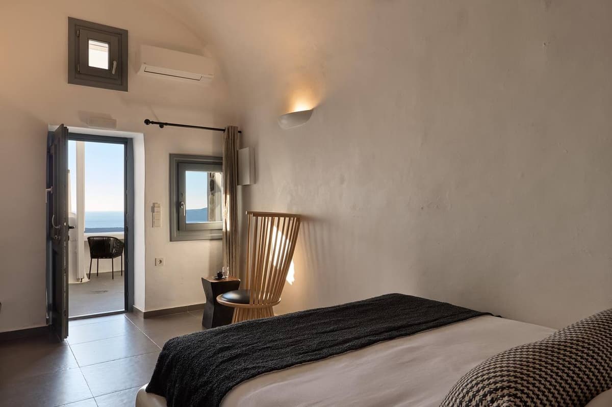 Double cave suite interior with whitewashed arched walls at Aroma Suites Santorini