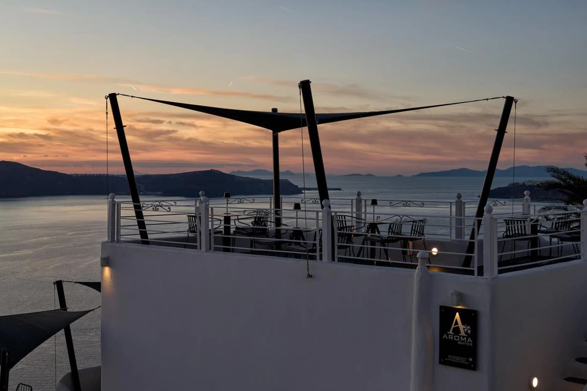 Rooftop terrace at Aroma Suites with sunset views over the Santorini caldera