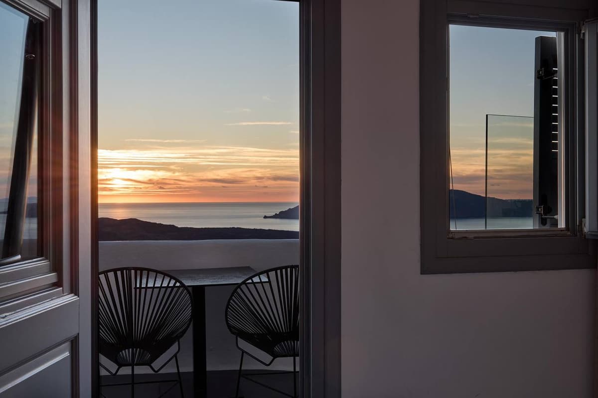 Sunset view through balcony door of double sea view room at Aroma Suites Santorini