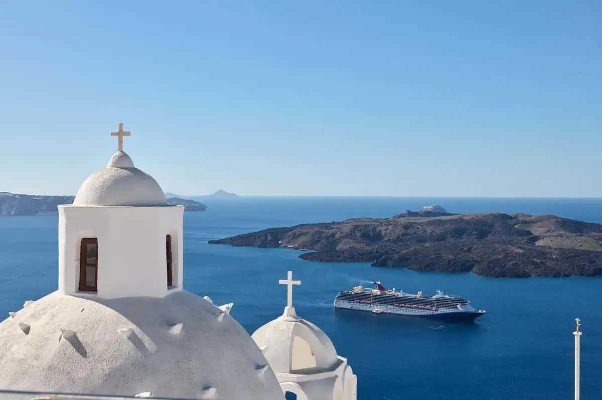 Church domes and cruise ship in the Santorini caldera panoramic view