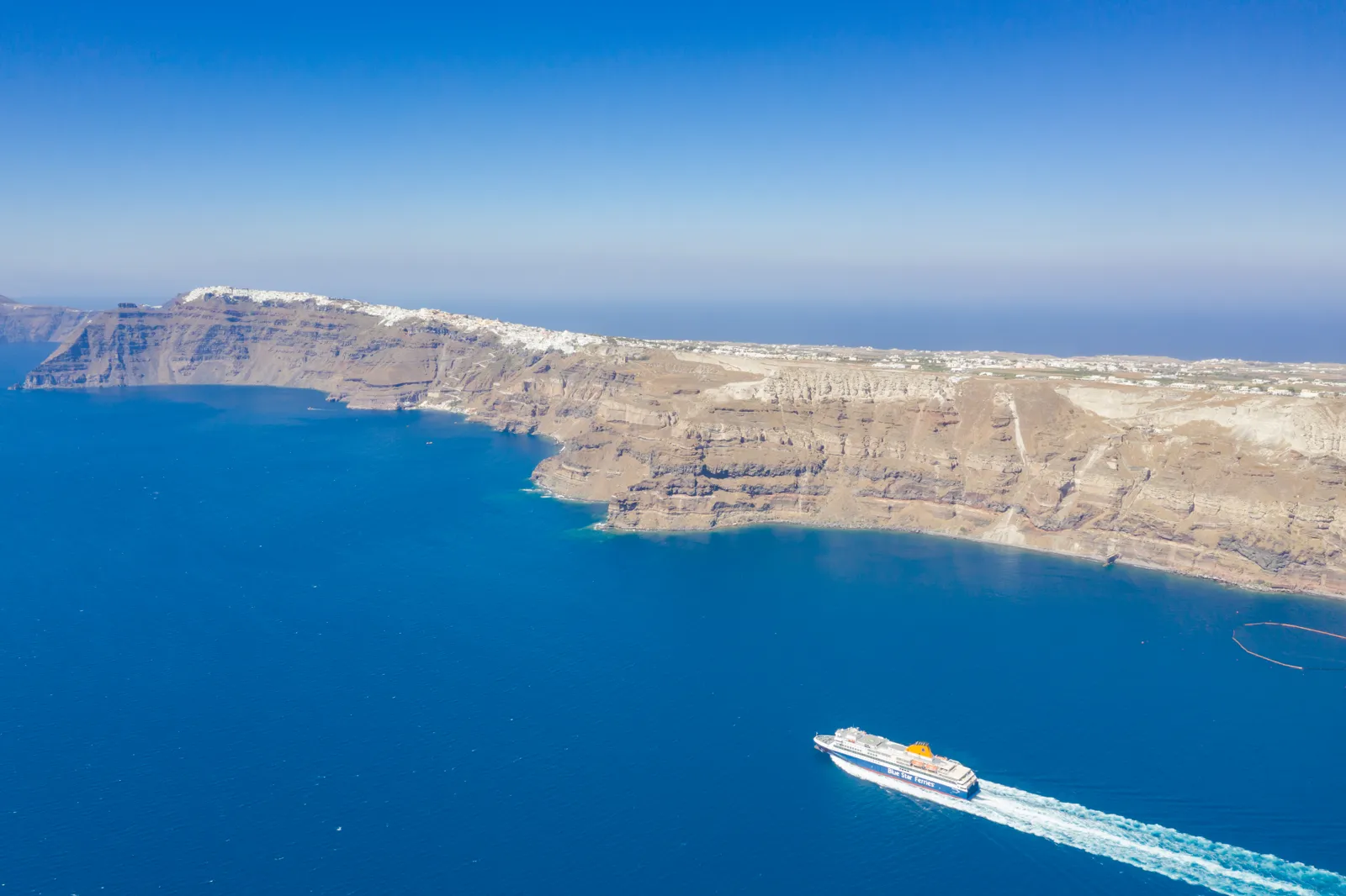 Ferry sailing into the Santorini caldera below the cliffs