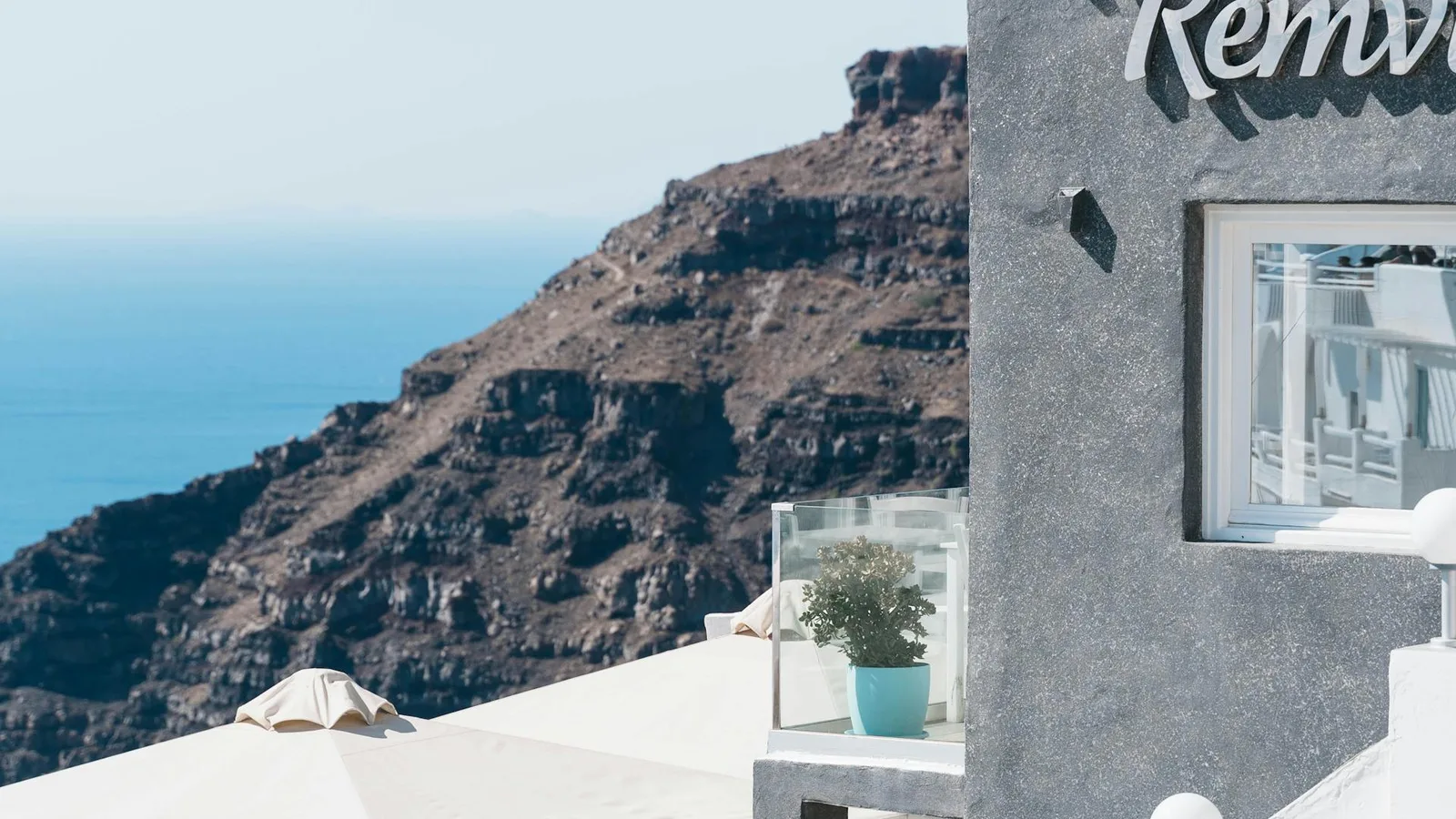 Outdoor terrace restaurant in Santorini with blue chairs overlooking the Aegean Sea