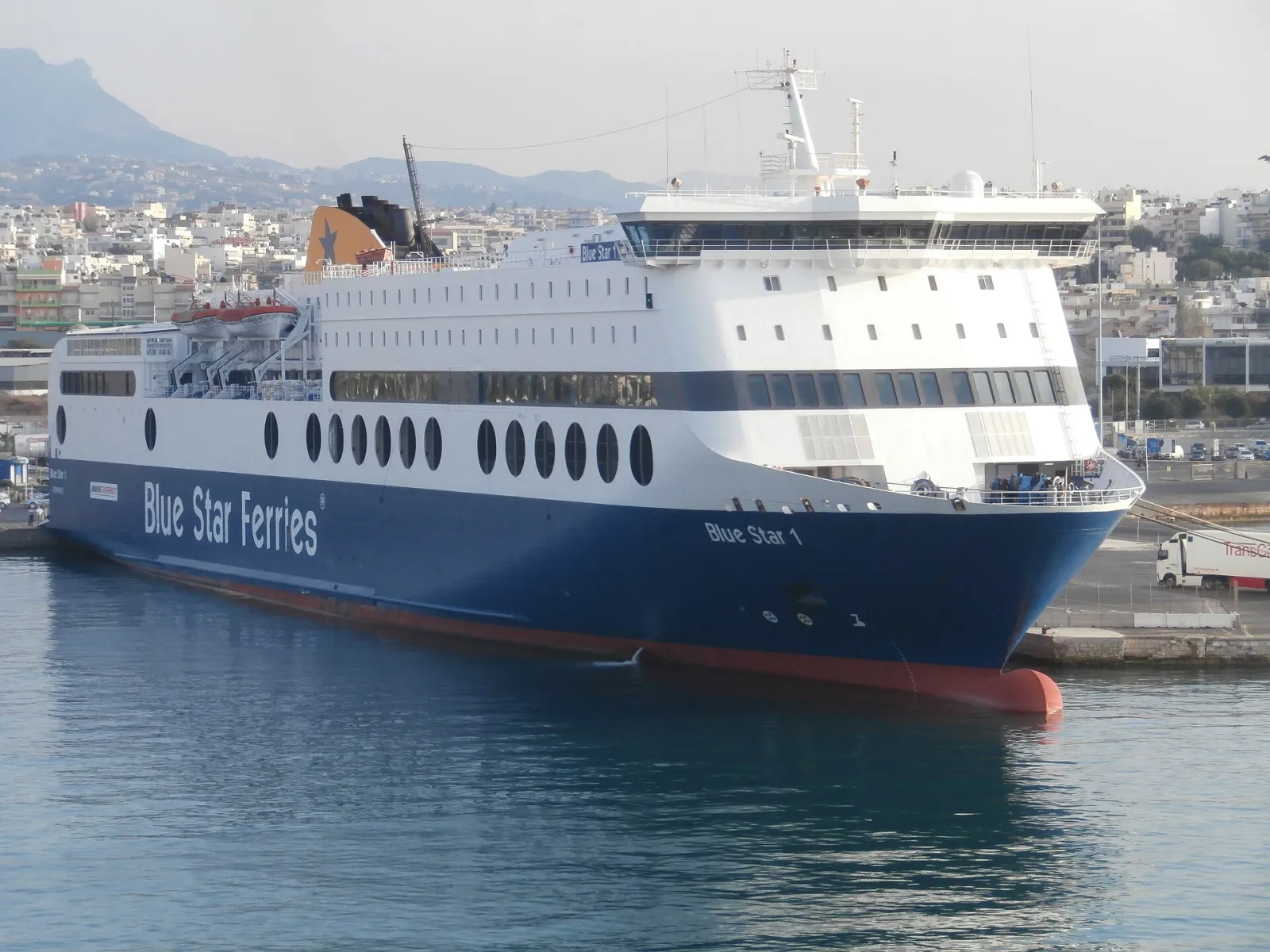 Blue Star 1 ferry docked at the port of Heraklion, with the city behind it
