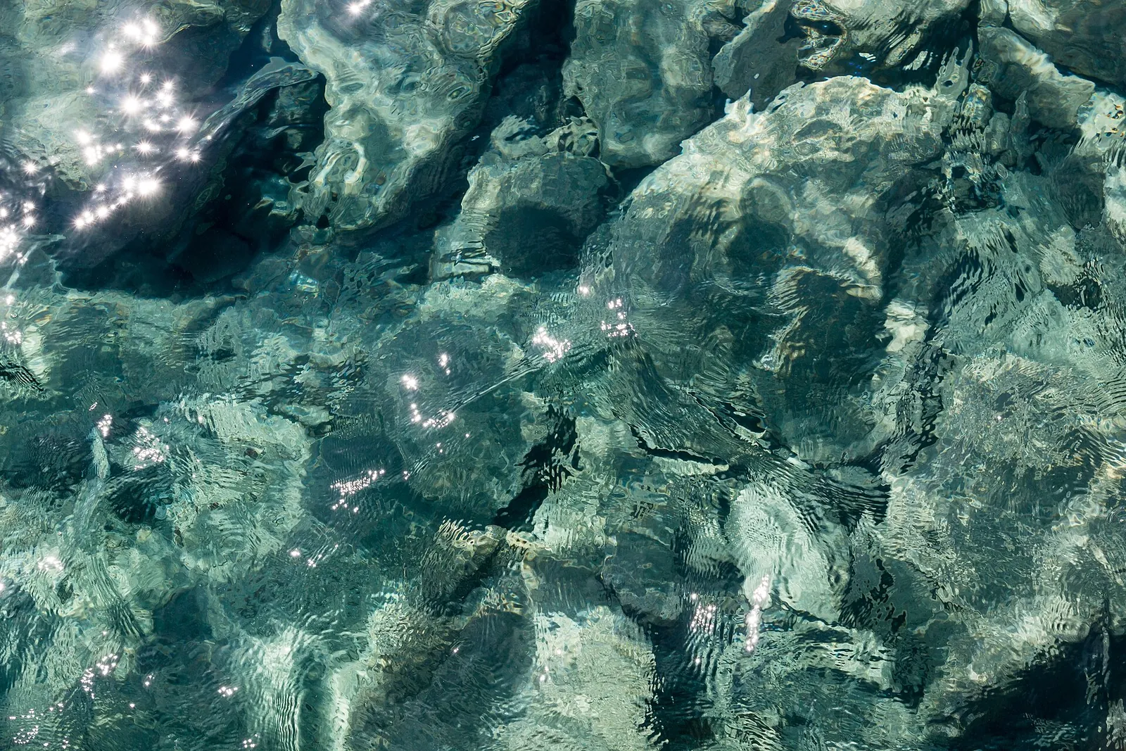 Clear water over volcanic rocks on the shore at Perissa