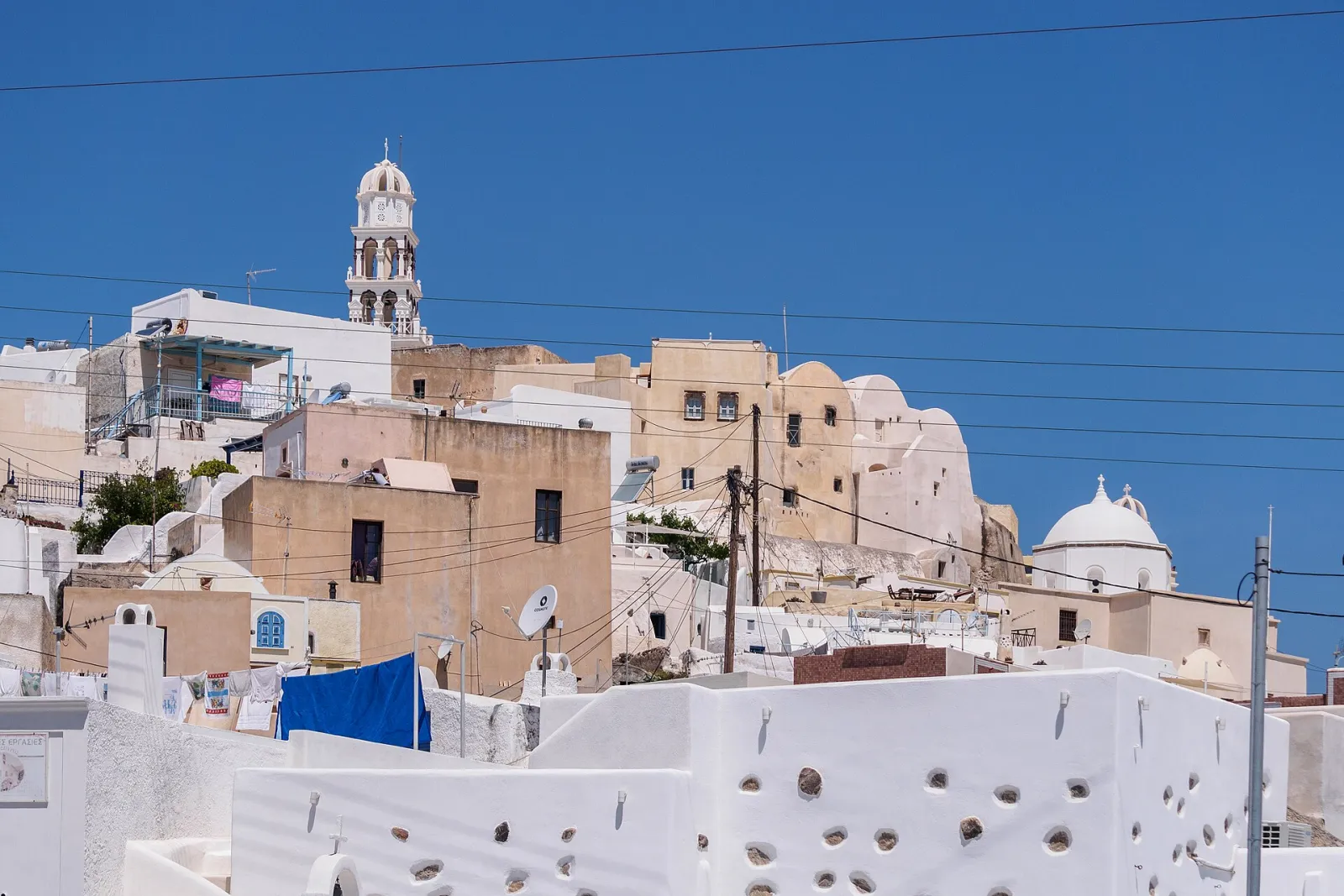 Houses of Emporio climbing towards the village bell tower, Santorini