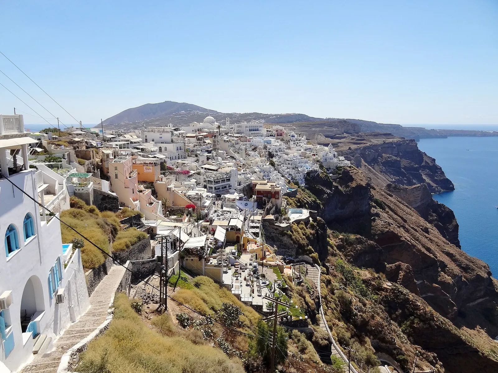 Fira's houses and terraces stacked along the caldera cliff, with a stepped lane on the left
