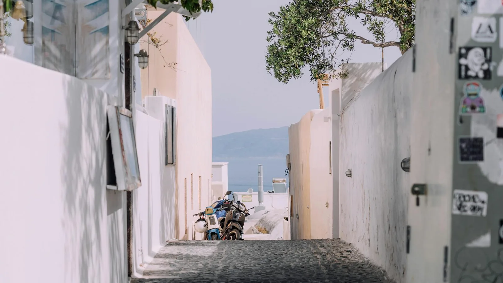 Cobblestone street winding through traditional whitewashed Greek architecture in Santorini village
