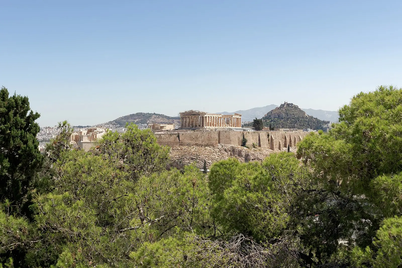 The Acropolis and the Parthenon above Athens, seen through pine trees from Philopappos Hill, with Lycabettus Hill behind