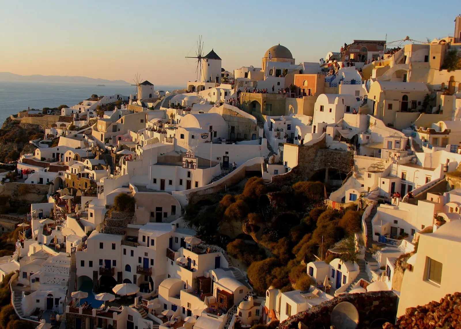 Oia's houses and windmills in golden light at sunset