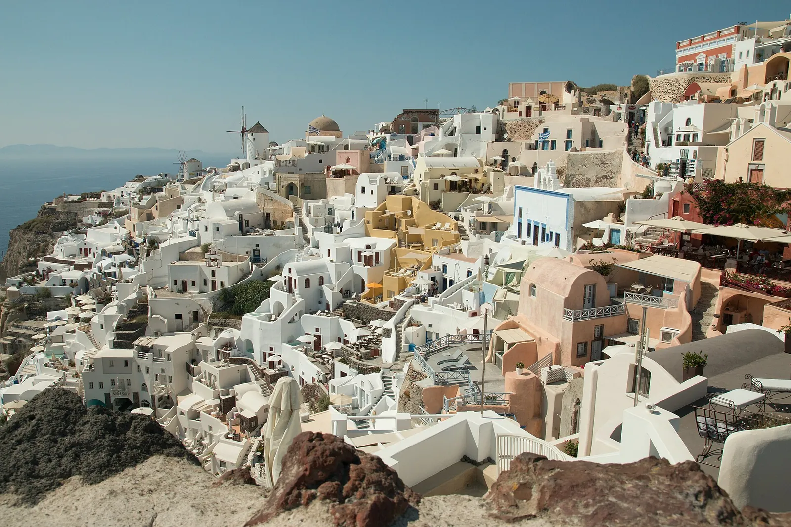 Oia's white and pastel houses and windmills, seen from the castle ruins
