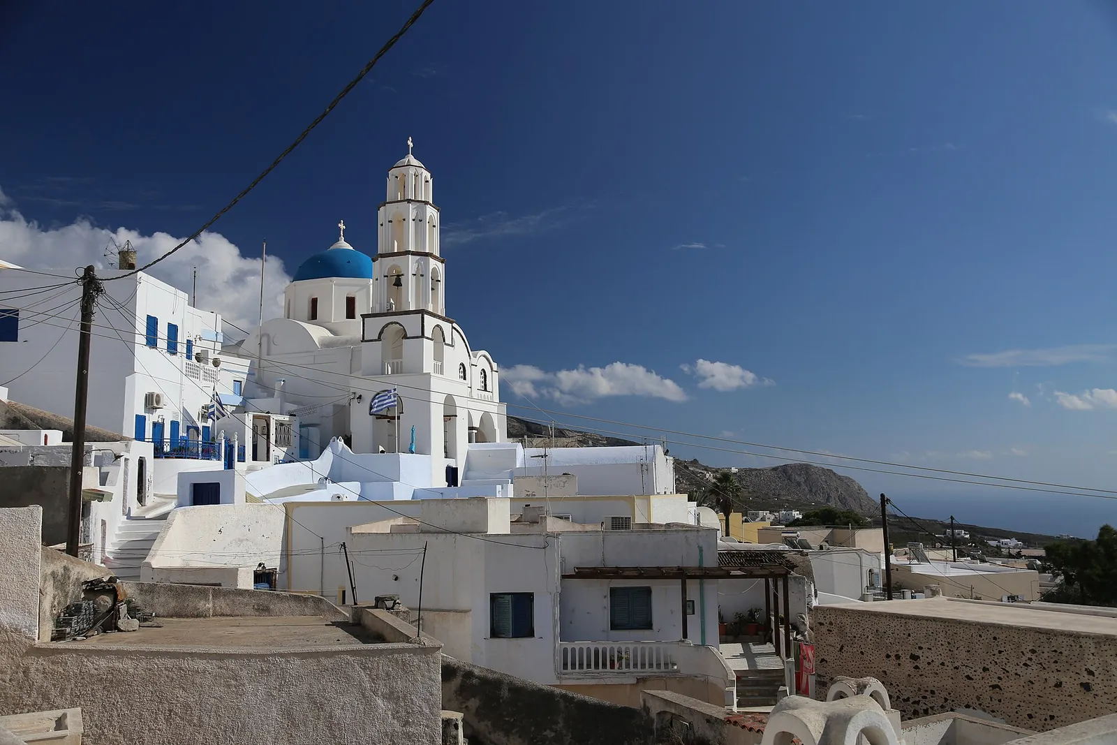 Bell tower and a blue dome above the white houses of Pyrgos