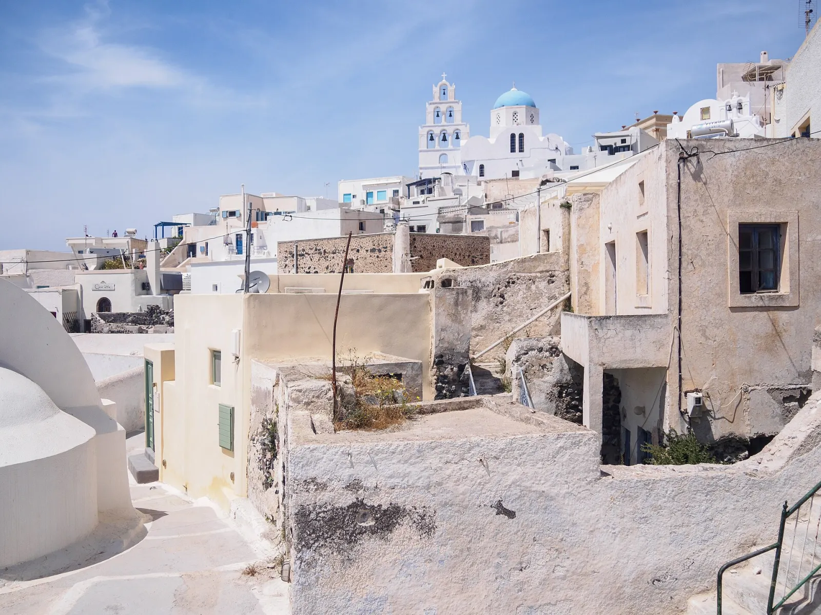 Old houses and rooftops of Pyrgos below the village church and bell tower
