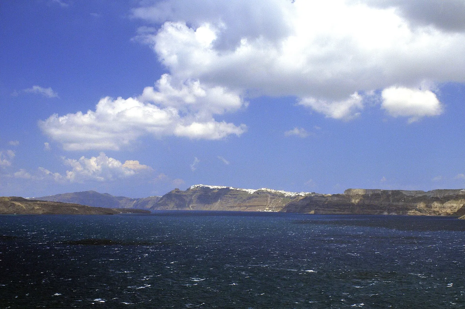 Wind-whipped dark water in the caldera below the Fira cliffs, seen from Akrotiri