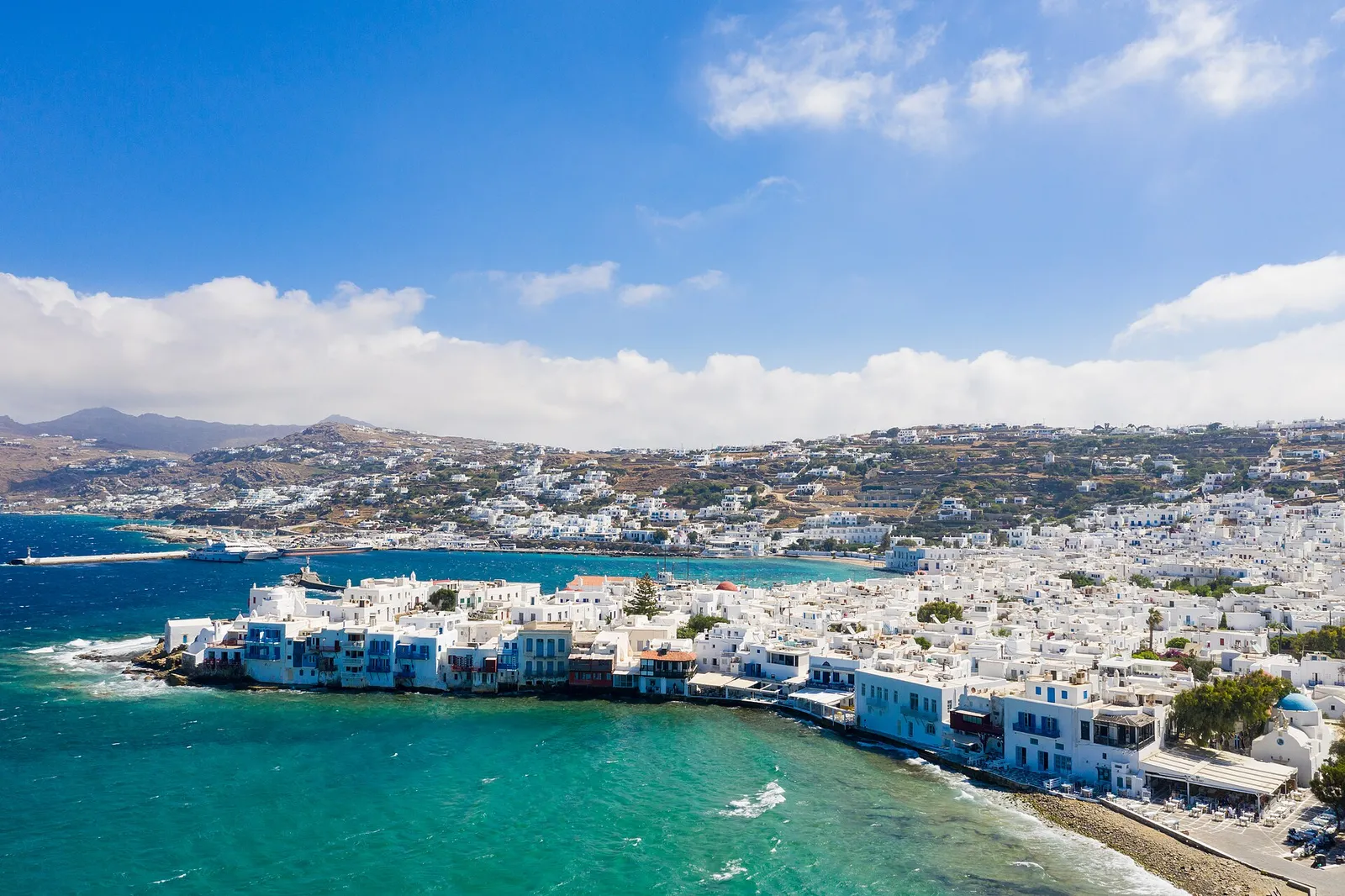 Aerial view of Little Venice in Mykonos town, with the old harbour and a moored ship across the bay
