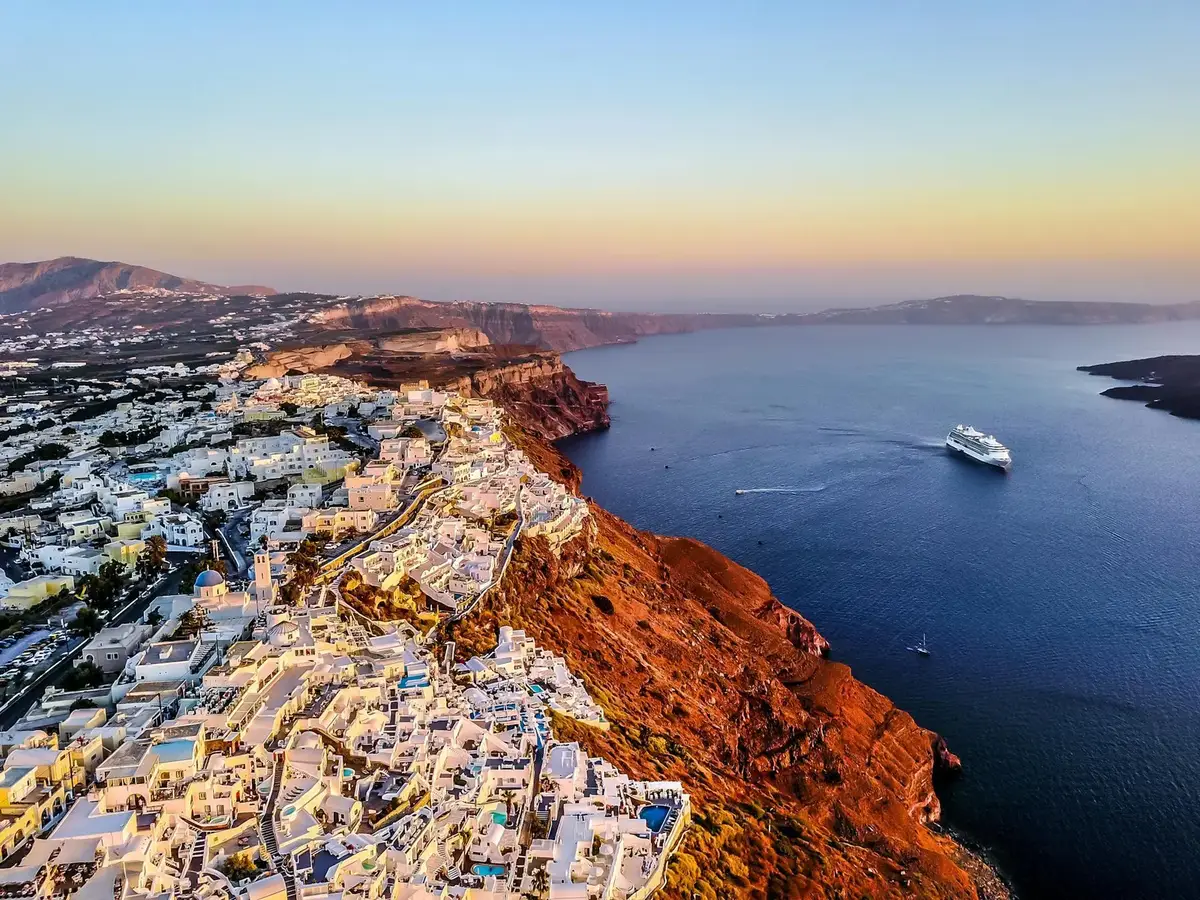 Iconic Santorini blue dome churches with white buildings overlooking the caldera