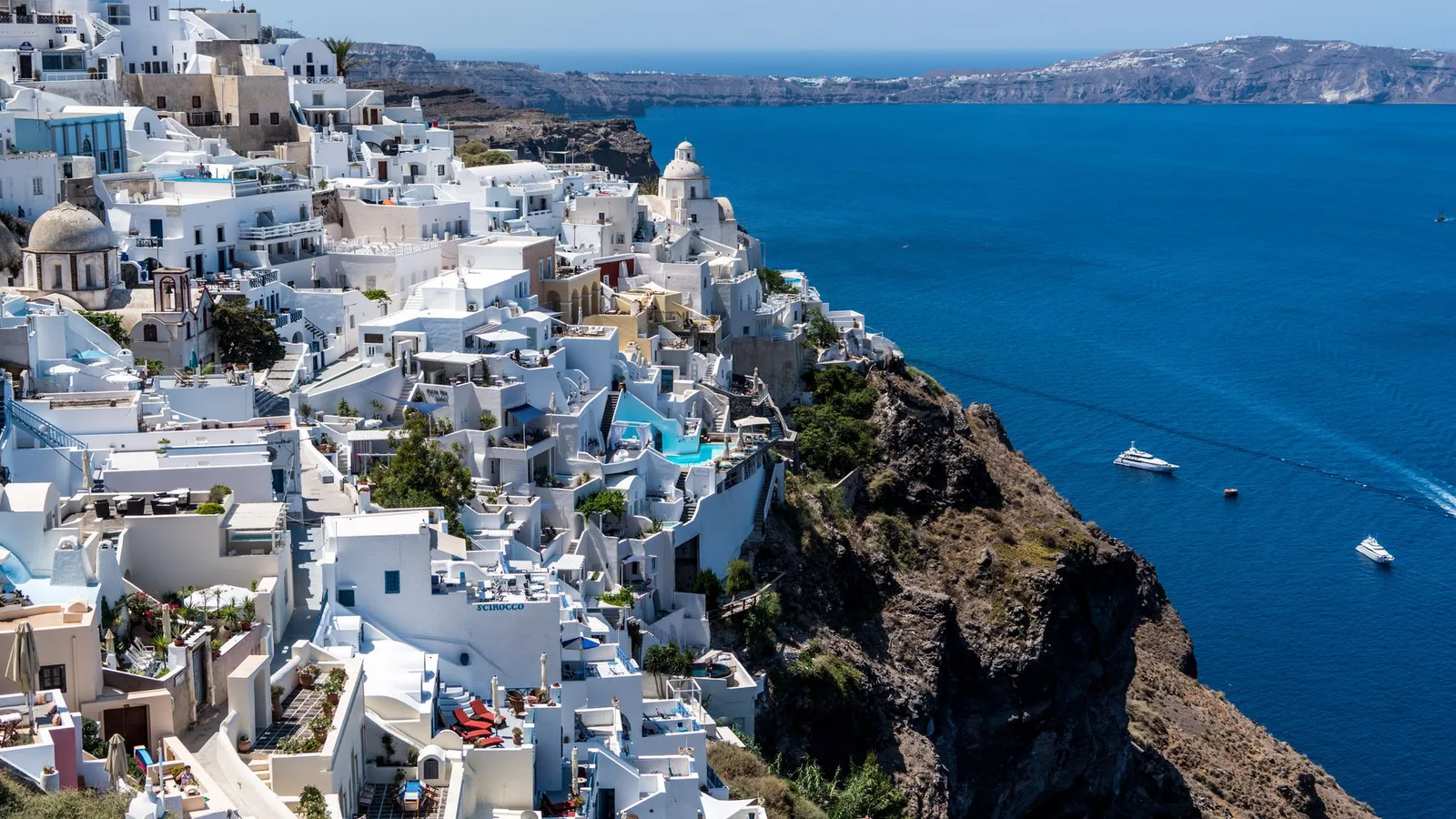 Santorini with kids: view over Fira's whitewashed caldera village and the blue Aegean Sea