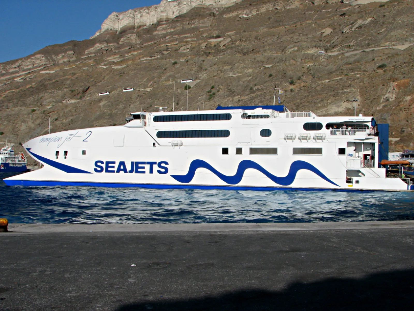 Seajets high-speed catamaran Champion Jet 2 moored at Athinios port below the Santorini cliffs