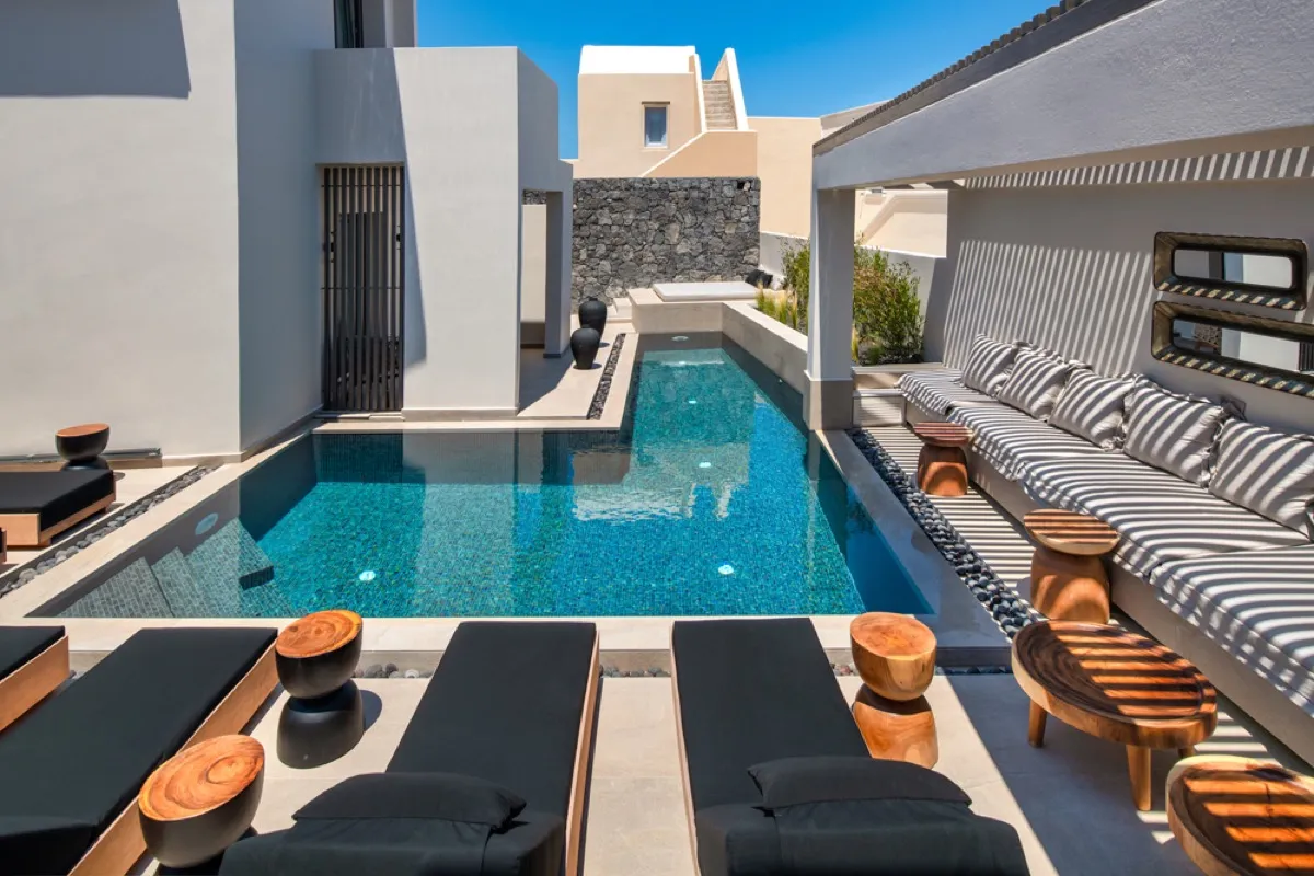 Uma Ray Suites outdoor pool with sun loungers and Cycladic architecture in Santorini